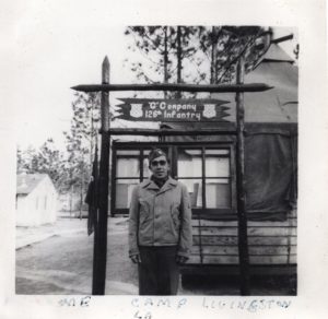 WWII soldier in front of company G sign at Camp Livingston, 1941